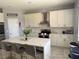 Modern kitchen with white cabinets, marble countertops, and gold hardware at 115 Essex Pl, Davenport, FL 33896