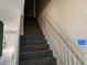 Gray carpeted staircase with white railing leading to the upper level at 115 Essex Pl, Davenport, FL 33896