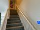 Gray carpeted staircase with white railing and Disney themed wall art at 115 Essex Pl, Davenport, FL 33896