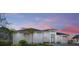 White two-story house with palm trees and a sunset at 118 River Ln, Ormond Beach, FL 32176