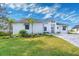 White, single-story house with palm trees and paver driveway at 118 River Ln, Ormond Beach, FL 32176