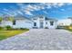 White house with gray paver driveway and landscaping at 118 River Ln, Ormond Beach, FL 32176