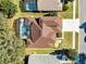 Aerial view of a home with a screened in pool, well-manicured lawn, and brown shingled roof at 13132 Coldwater Loop, Clermont, FL 34711