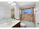 Well-lit bathroom featuring a tub, shower, single vanity, and neutral-toned tile at 13132 Coldwater Loop, Clermont, FL 34711