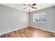 Bedroom featuring hardwood flooring, a ceiling fan, and a window at 13132 Coldwater Loop, Clermont, FL 34711