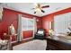 Home office with red walls, a desk, and a comfy armchair at 13132 Coldwater Loop, Clermont, FL 34711