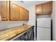 Laundry room with built-in cabinets, butcher block countertop, and full-size washer/dryer at 13132 Coldwater Loop, Clermont, FL 34711