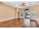 Open-concept living room featuring hardwood floors, a ceiling fan, and sliding doors to the pool at 13132 Coldwater Loop, Clermont, FL 34711