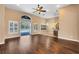 Bright living room with hardwood floors, a ceiling fan, and an opening to a small bar at 13132 Coldwater Loop, Clermont, FL 34711