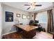 Home office featuring hardwood floors, a desk with computer and custom shelving at 13132 Coldwater Loop, Clermont, FL 34711