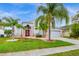 Brick house with red door, palm trees, and a well-manicured lawn at 13656 Crystal River Dr, Orlando, FL 32828