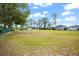 Expansive front yard features mature trees and lawn leading to a charming one-story home under a sunny sky at 14415 Lake Huckleberry Ln, Winter Garden, FL 34787