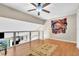 Bright loft bedroom with wood flooring, ceiling fan, and large wall art at 174 Northshore Cir, Casselberry, FL 32707