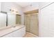 Bathroom featuring a glass-enclosed shower, a vanity, and a large mirror at 2302 Midtown Ter # 1228, Orlando, FL 32839