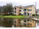 Waterfront condos with colorful facade, private balconies, and dock access on a tranquil pond at 2302 Midtown Ter # 1228, Orlando, FL 32839