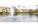 Scenic view of an apartment complex pond with fountain, complemented by colorful buildings and lush landscaping at 2302 Midtown Ter # 1228, Orlando, FL 32839