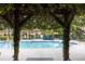 Community swimming pool area featuring blue lounge chairs, wooden pergola, and lush landscaping, providing a relaxing outdoor space at 2302 Midtown Ter # 1228, Orlando, FL 32839