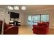 Living room with red couches, large TV and sliders to lanai at 2408 Addison Creek Dr, Kissimmee, FL 34758