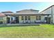 Lush backyard featuring covered patio with ample seating and manicured lawn at 2530 Domenico Paul Way, Orlando, FL 32810