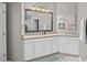 Well-lit bathroom boasts granite counters, white cabinets, and an oversized framed mirror at 2530 Domenico Paul Way, Orlando, FL 32810