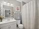 Updated bathroom featuring a modern vanity, decorative mirror, and a shower with chevron-patterned curtain at 2530 Domenico Paul Way, Orlando, FL 32810