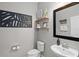 Small bathroom with toilet, sink, and decorative shelving at 2530 Domenico Paul Way, Orlando, FL 32810