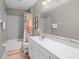 Bathroom featuring vanity with white cabinetry, large mirror, tub with shower at 2530 Domenico Paul Way, Orlando, FL 32810