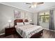 Comfortable bedroom featuring a ceiling fan, wood-look floors, and natural light from the window at 2530 Domenico Paul Way, Orlando, FL 32810