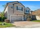 Two-story house with gray siding, gray garage door, and a brick driveway at 2530 Domenico Paul Way, Orlando, FL 32810