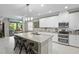Modern kitchen featuring a large island with seating, stainless appliances, and white cabinetry at 2530 Domenico Paul Way, Orlando, FL 32810