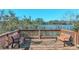 Scenic wooden deck with benches overlooking a serene lake and lush greenery under a clear blue sky at 2530 Domenico Paul Way, Orlando, FL 32810