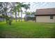 Large backyard with screened patio, grass, and palm trees at 2612 Keswick Ct, Kissimmee, FL 34744