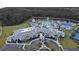 A high-angle view of a community center and entrance road, with a pool, lake, and lush landscaping at 2812 Ruby Rose Ln, St Cloud, FL 34771