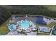 Aerial view of community pool with lake, fountain, palm trees, white lounge chairs, and cabanas at 2812 Ruby Rose Ln, St Cloud, FL 34771