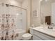 Clean bathroom featuring a shower with seashell curtain, white sink vanity, and decorative wall art at 2812 Ruby Rose Ln, St Cloud, FL 34771