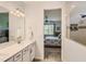 Bathroom leading to bedroom features double sinks, quartz counters, tile floors, and a shower with tiled walls at 2812 Ruby Rose Ln, St Cloud, FL 34771