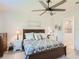 Bedroom features a ceiling fan, wood furniture, and an en-suite bathroom at 2812 Ruby Rose Ln, St Cloud, FL 34771