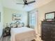 Cozy bedroom with ceiling fan, neutral walls, and dresser topped with decorative mirror at 2812 Ruby Rose Ln, St Cloud, FL 34771