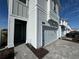 Side view of townhome's entrance and garage, showing gray siding and landscaping at 2900 Title St, Kissimmee, FL 34746