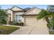 Tan one-story house with palm trees, two-car garage, and landscaped lawn at 2920 River Birch Dr, Kissimmee, FL 34741