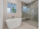 Spa-like bathroom featuring a freestanding soaking tub and walk-in shower at 3015 Kensington Ave, Davenport, FL 33837