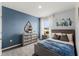 Bright bedroom with gray dresser and full bed, featuring a blue accent wall at 3570 Fort Mellon Ln, Sanford, FL 32773