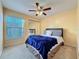 Bright bedroom with a queen-size bed, ceiling fan, and mirrored closet doors at 4818 Marks Ter # 385 B2, Orlando, FL 32811