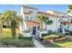 Townhome with a tiled roof, palm trees, and a well-manicured lawn at 4818 Marks Ter # 385 B2, Orlando, FL 32811