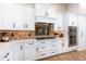 White kitchen with stainless steel appliances and diamond-patterned backsplash at 6228 Lecco Way, Windermere, FL 34786