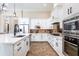 Modern kitchen featuring white cabinetry, stainless steel appliances, and tile flooring at 6228 Lecco Way, Windermere, FL 34786