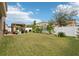 Large backyard with grassy lawn, tropical plants and a wooden pergola at 648 Cortona Dr, Orlando, FL 32828