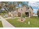 Two-story house with brown exterior, brick driveway, and landscaping at 648 Cortona Dr, Orlando, FL 32828