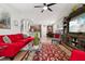 Bright living room with red sectional sofa and a large TV at 648 Cortona Dr, Orlando, FL 32828