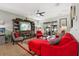 Bright living room with red sectional sofa and a large TV at 648 Cortona Dr, Orlando, FL 32828